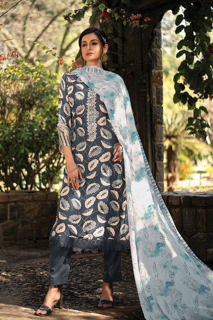 A woman modeling a traditional Indian suit set in an outdoor garden setting. The outfit features a dark gray kameez with beige and white paisley patterns, paired with dark gray trousers and a light blue and white printed dupatta. | Wholesale Embroidered Kurta Set for women | Sri Fashion