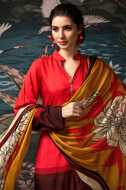 A woman modeling a traditional South Asian outfit featuring a bright red kurta, dark brown sleeves, and a mustard yellow dupatta with a large white floral print and black borders, set against a dark patterned backdrop. | Source wholesale dual tone floral print pure dola silk 3 piece kurta set by Sri Fashion available through Saanjaa. Contact us for wholesale price and MOQ. 

