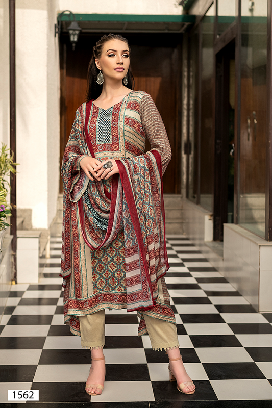 A woman models a traditional South Asian suit set with a printed dupatta in an indoor corridor with a black and white checkered floor. The outfit features a beige and brown suit with red and blue patterns, paired with beige trousers and a matching patterned dupatta. | Wholesale Off White Ethnic Muslin Suit Set | Sri Fashion
