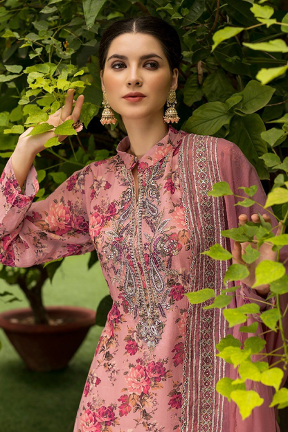 A woman wearing a pink floral traditional outfit with ornate embroidery and a matching dupatta, posed outdoors among green leaves. | Wholesale Straight Cut Kurta Set For Women | Sri Fashion
